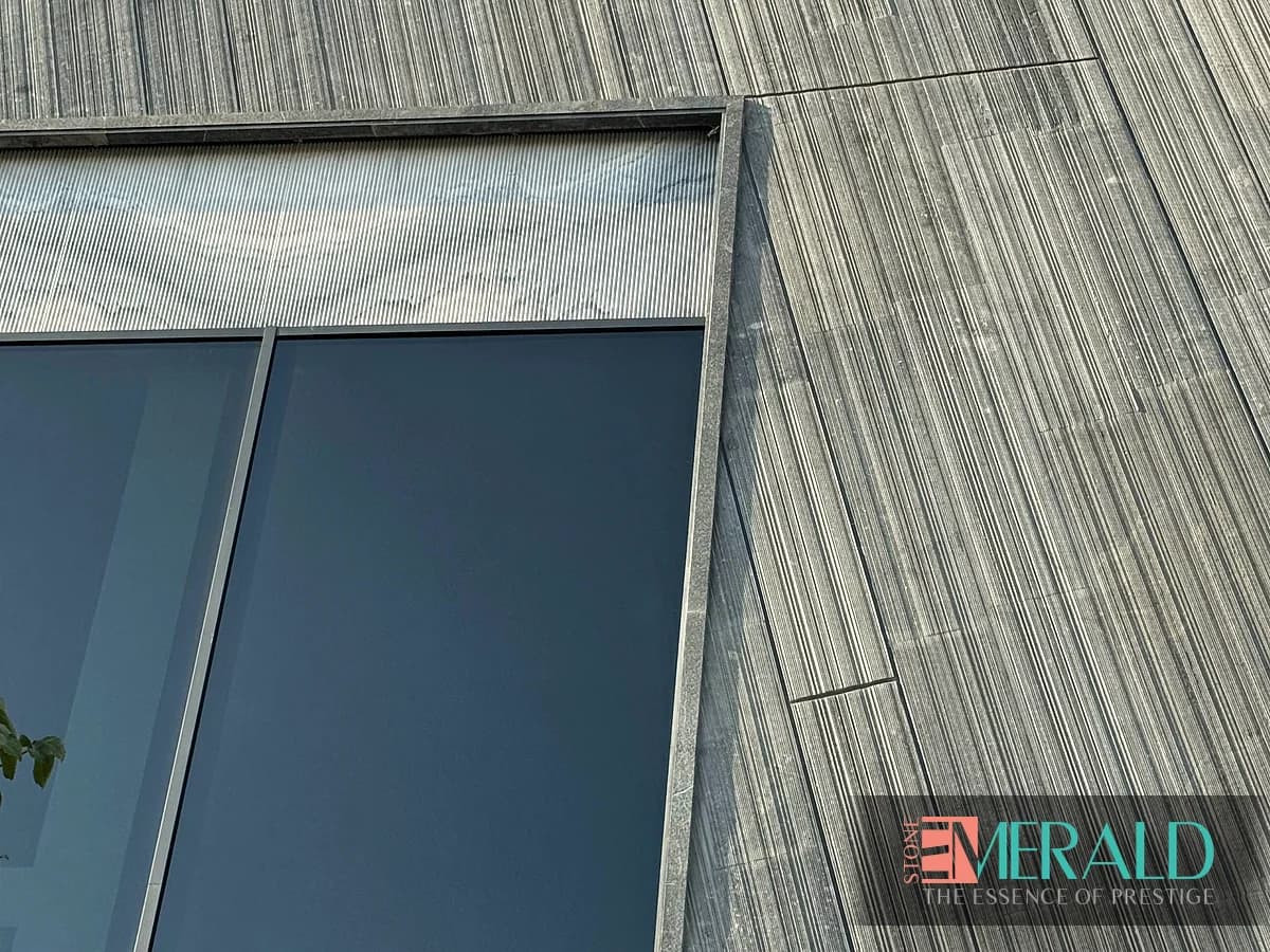 نمای نزدیک cladding سنگ طوسی شیاردار با جزئیات پنجره در پروژه مهندسی سنگ
